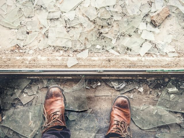 Person in boots standing on broken glass