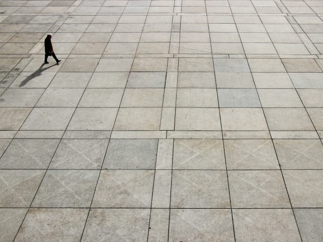 man walking across the plaza