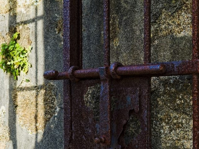 A steel lock on a steel gate.