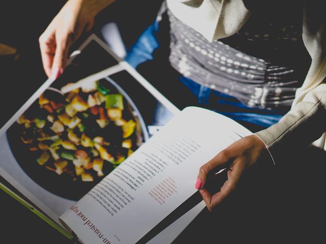 person looking at a recipe in a cookbook