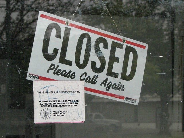A closed sign hangs on a window.