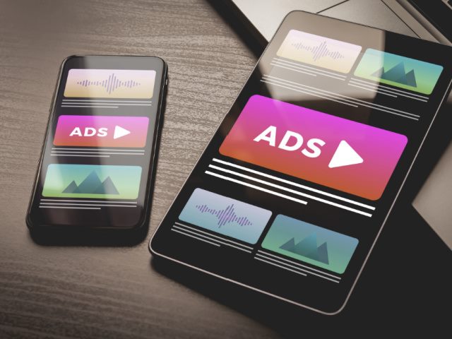 Online native video ad banner on a mobile phone sitting on a desk