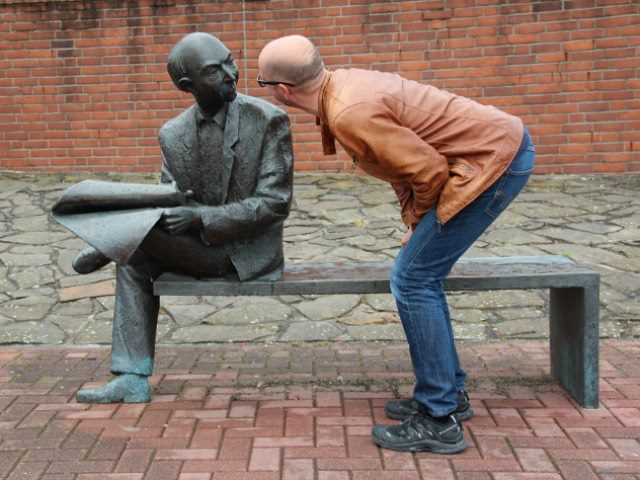 man talking to a scuplture