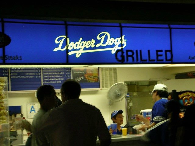 People in front of a vendor at Dodger Stadium that is titled "Dodger Dogs."