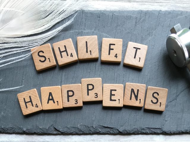 scrabble pieces on a gray slate the spell out shift happens