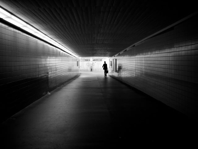 man walking down a dark hallway