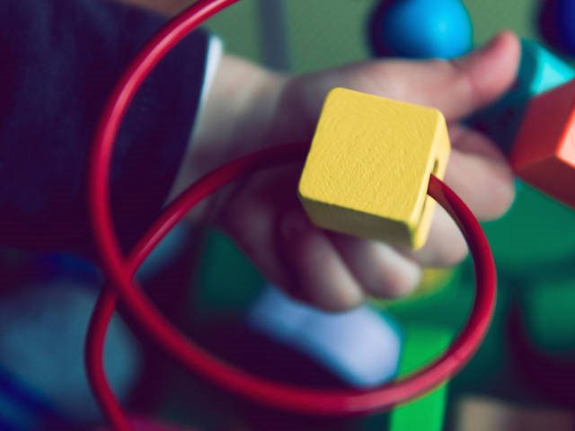 child's hand on a toy