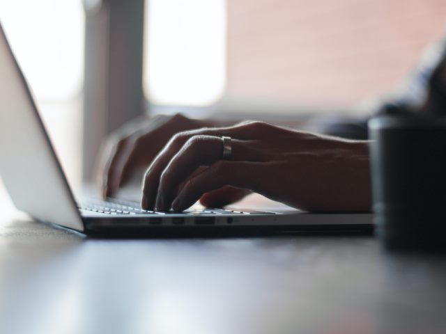 man typing on a laptop computer