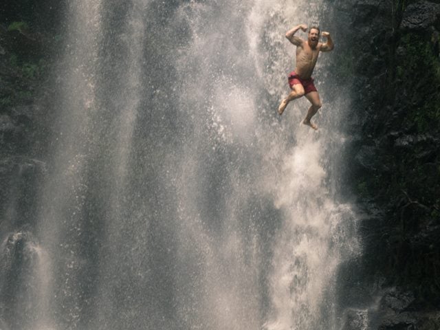 man jumping off waterfall