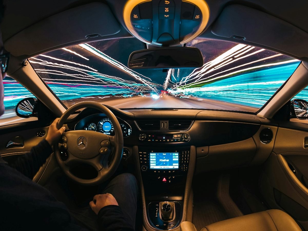 Inside of a futuristic car, looking at the angle from the backseat vantage point.