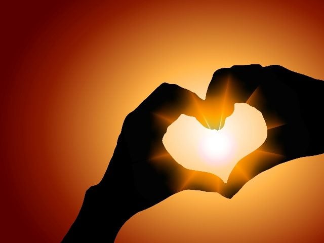 Two hands come together and form a heart sign with a gorgeous sunset in the background in piece about building trust with customers. 