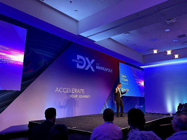Sitecore DX Minnesota 2023, a shot of the conference stage flooded in blue and purple lights. 