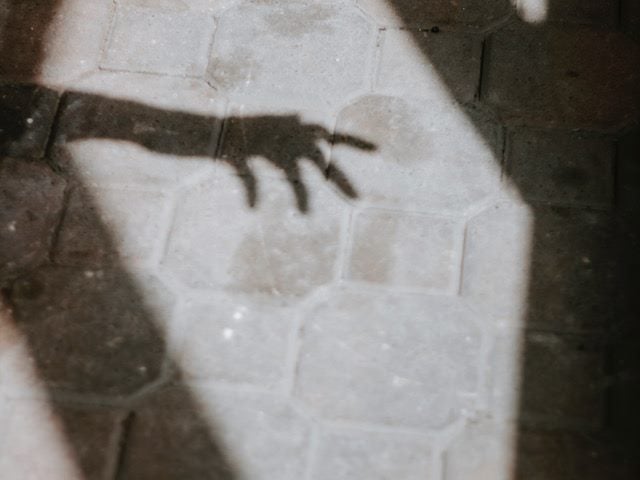 the shadow  of  an arm stretching  out