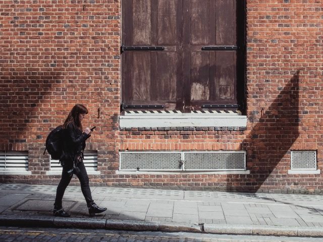 staring at phone, walking down the street