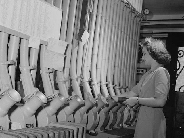 woman sending messages through a pneumatic tube system