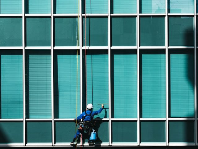 lone window  washer outside a high rise  office building