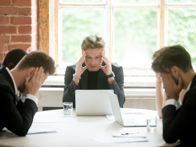 Stressed boss and executive team searching problem solution at meeting - bad data makes for bad decisions concept