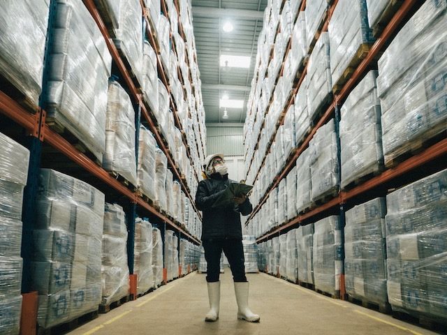 warehouse worker wearing protective  gear taking inventory