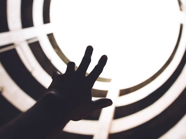 hand reaching up towards light