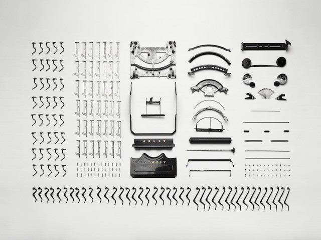 typewriter broken apart and organized according to parts