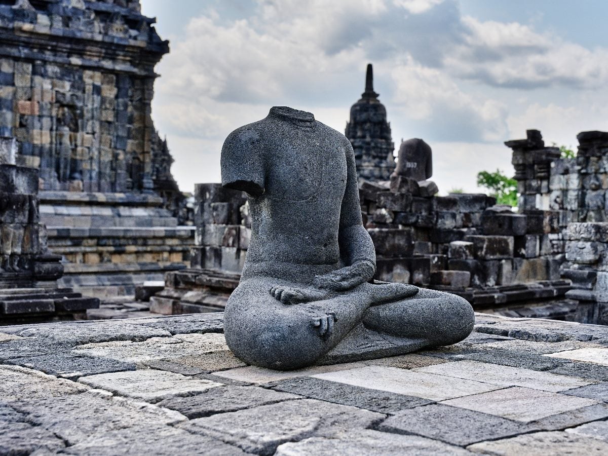 Headless stone statue at an ancient temple, symbolizing architectural purity without context or connection.