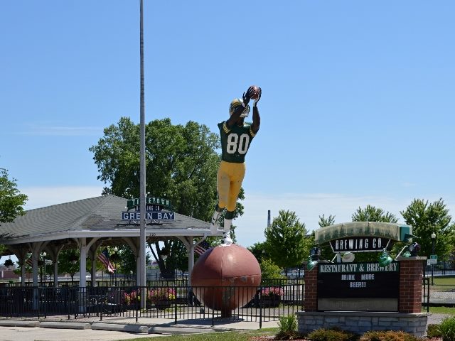 The Receiver statue, a 22-foot-tall public statue in Green Bay, Wisconsin, associated with the Green Bay Packers football team. The player is catching a football and standing on top of a large football.
