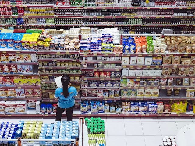 woman doing inventory by hand in a supermarket