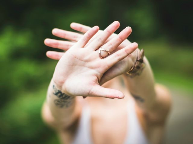 a woman holding her hands in front of her face