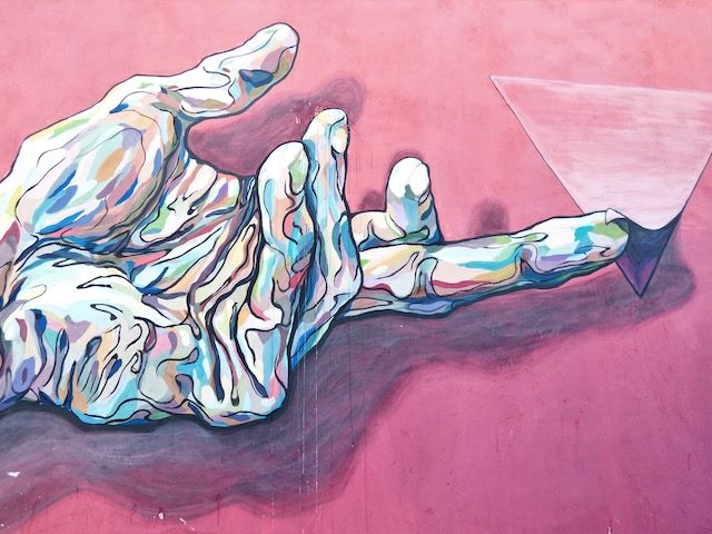 graffiti painting of a hand lifting and revealing a hidden view