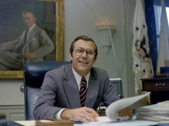 Donald Rumsfield working for the US government at an office desk.
