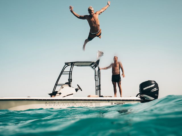 man jumping off  a boat