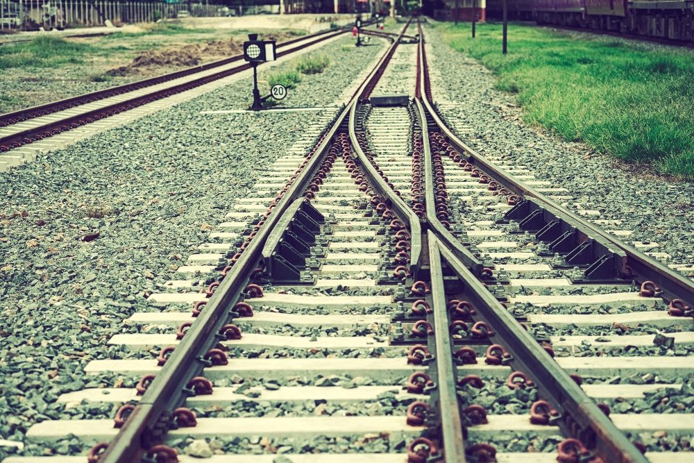 This image depicts a set of railway tracks that diverge into two separate paths, a visual metaphor for strategic decision-making such as BlueConic's acquisition of Jebbit. The image captures the moment where the paths split, symbolizing the significant and impactful choices that companies face when merging with or acquiring another entity. The diverging tracks can be seen as representing the integration of different technologies or teams, which must be carefully managed to ensure they lead to a successful, unified direction.