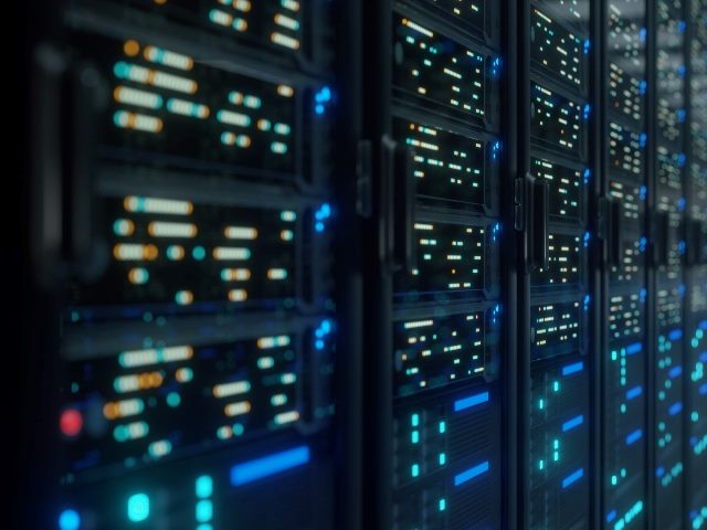 The modern interior server room data center with lights showing on the servers in piece about developing data-driven strategies for business. 