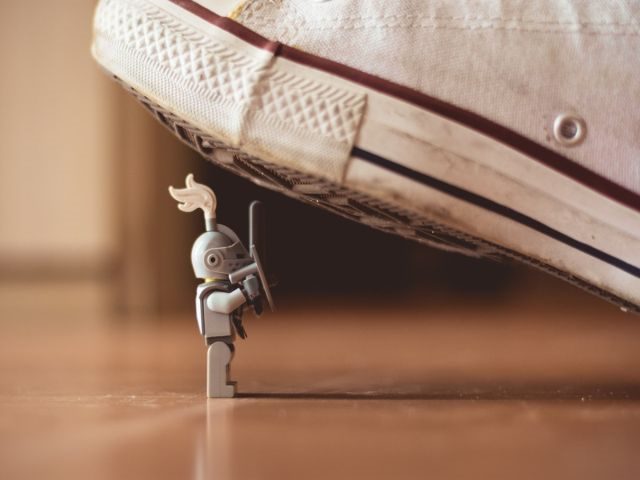 A Lego knight about to be stepped on by a converse sneaker - microservices security concept