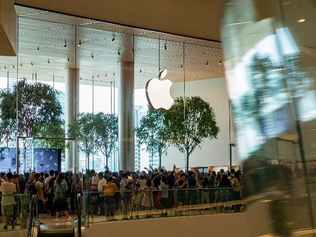 Dozens of people in line visiting the first Apple store in Thailand at a shopping mall.