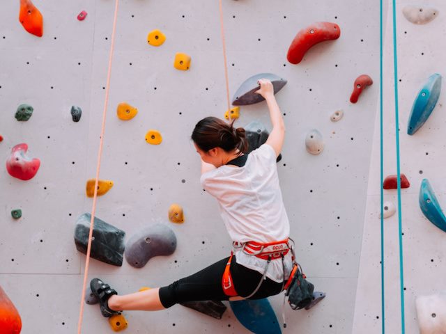 woman doing indoor rock climbing