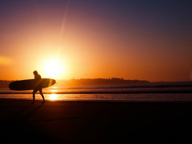 surfer walking into the sunset
