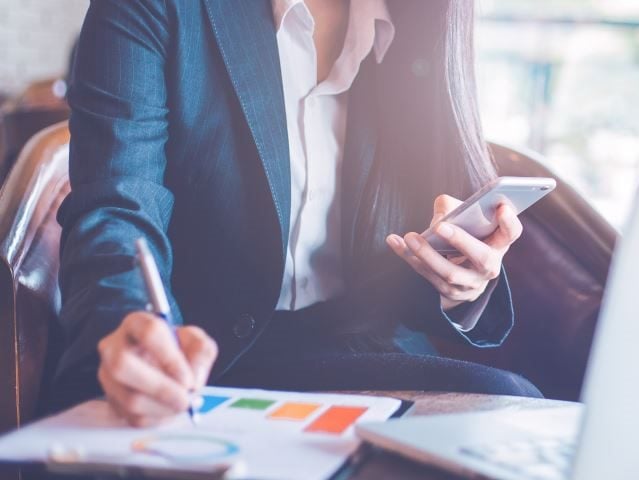 A businesswoman getting work done on her mobile device.