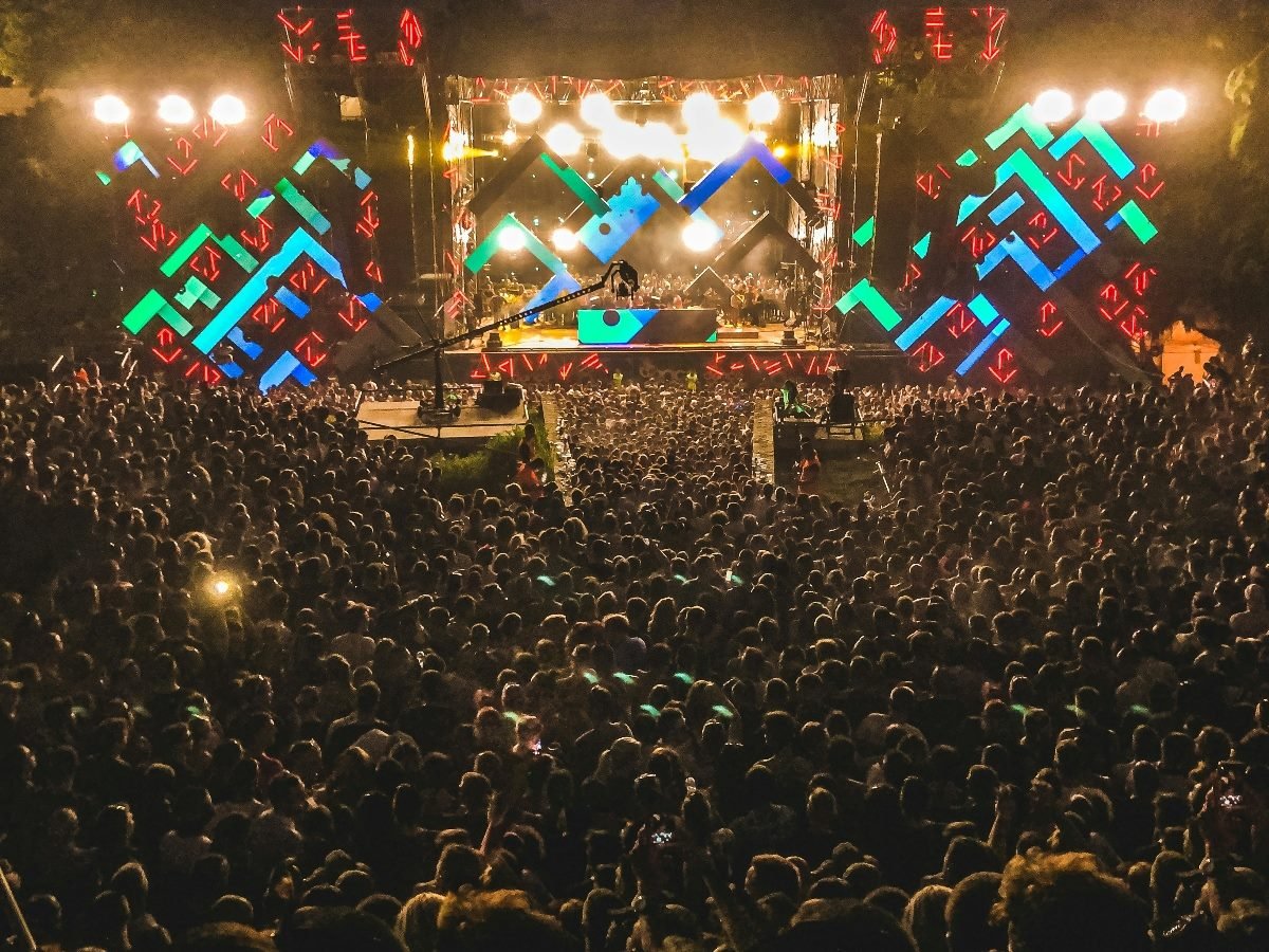 Shot from sky view of a big crowd of people attending a concert.