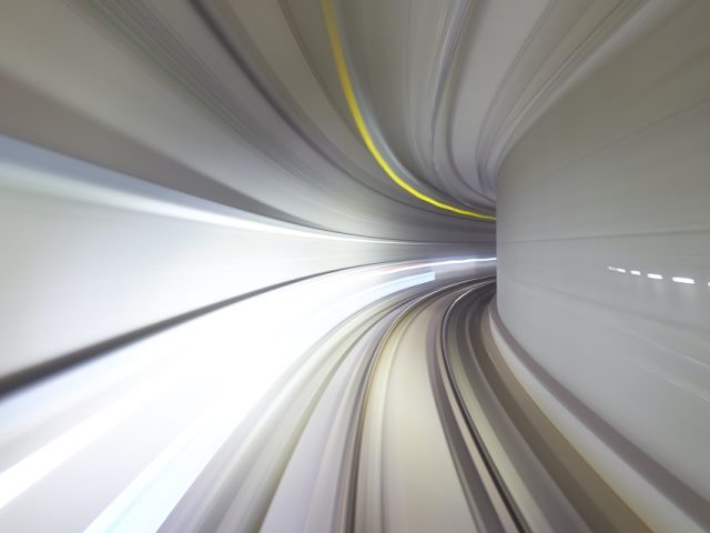 time lapse photo of a gray subway tunnel with yellow and white lights