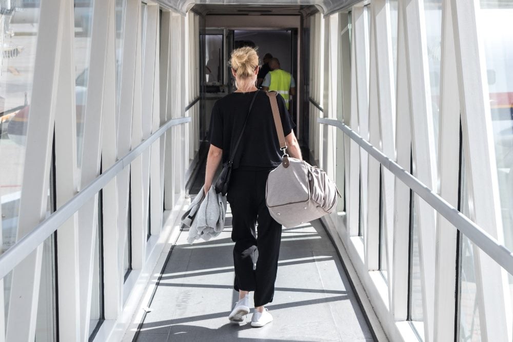 A passenger walks along the onboarding corridor toward a plane in story about designing effective user onboarding best practices.