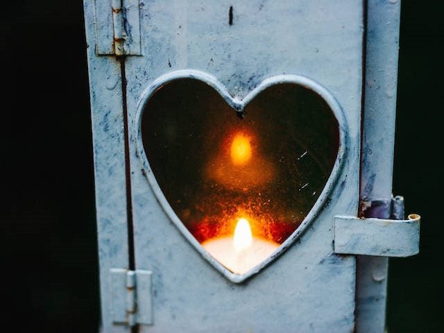 flame behind a heart cut out in a door