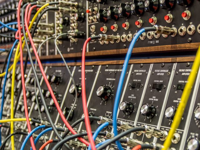 multi-colored cords plugging into an audio mixer