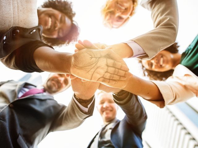 group with hands together in circle
