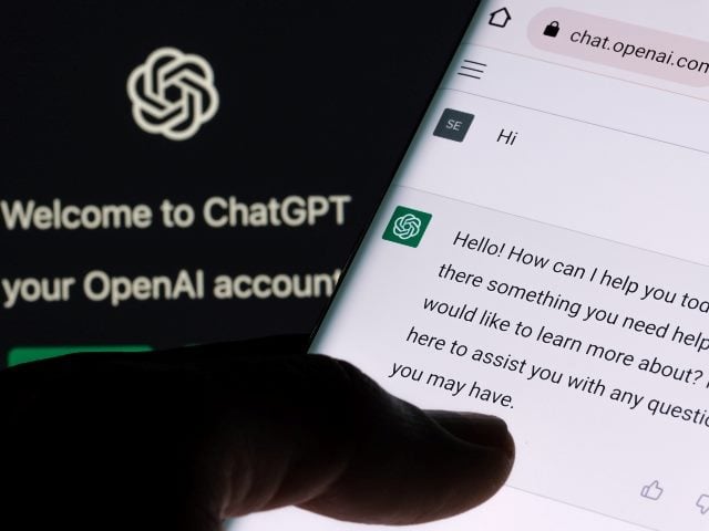 ChatGPT chatbot screen seen on smartphone and laptop display with ChatGPT login screen in the background.  