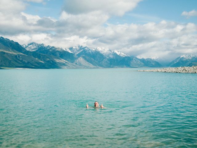 man swimming  in  a lake giving a thumbs up