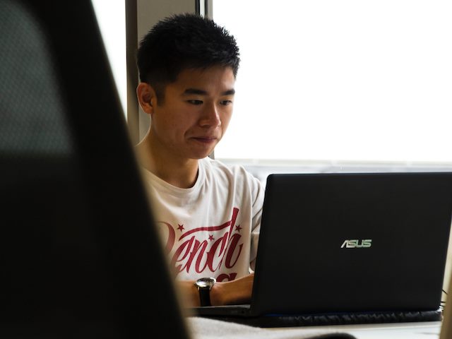 man wearing a t shirt working on laptop