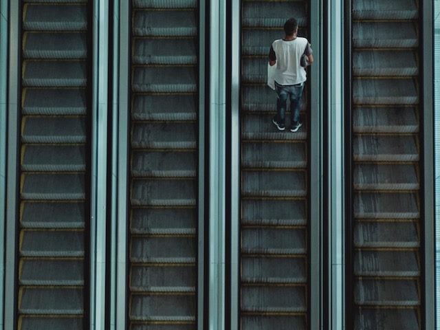 escalator going up with one  person on it