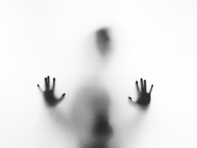 shadow person behind opaque glass