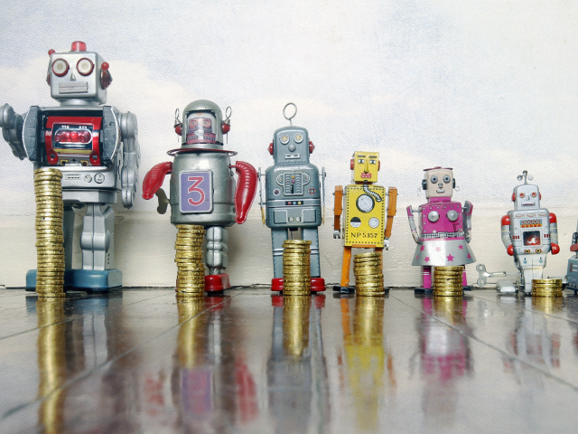 A group of toy robots in a line grouped by size from biggest to smallest, in front of each robot there is a stack of coins that coincides with the size of the robot - AI return on investment